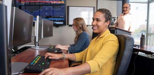 Two students in Finance Lab, professor in background